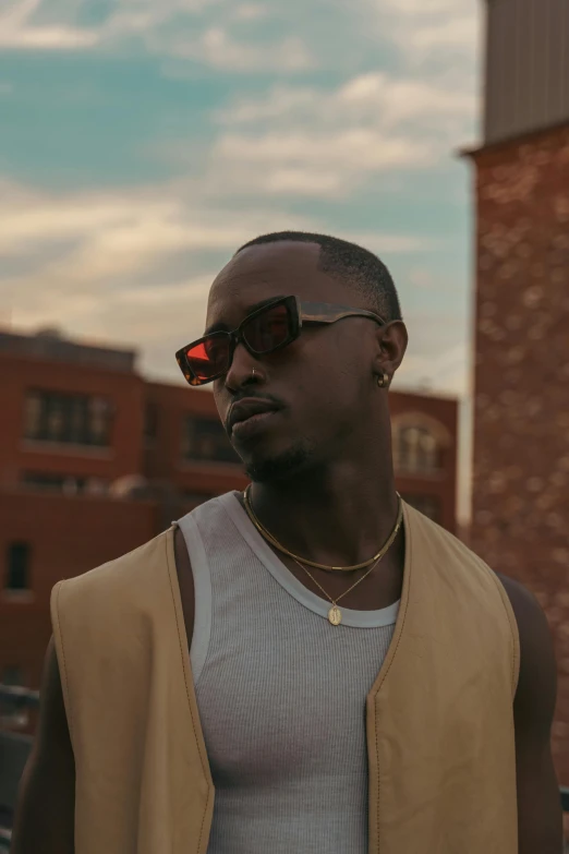 a man with sunglasses wearing a tan vest