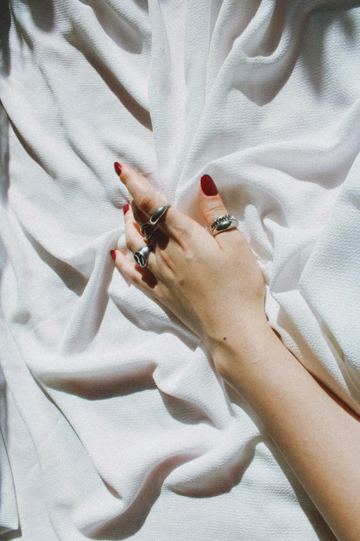 a woman holding onto an unmade blanket on her hands