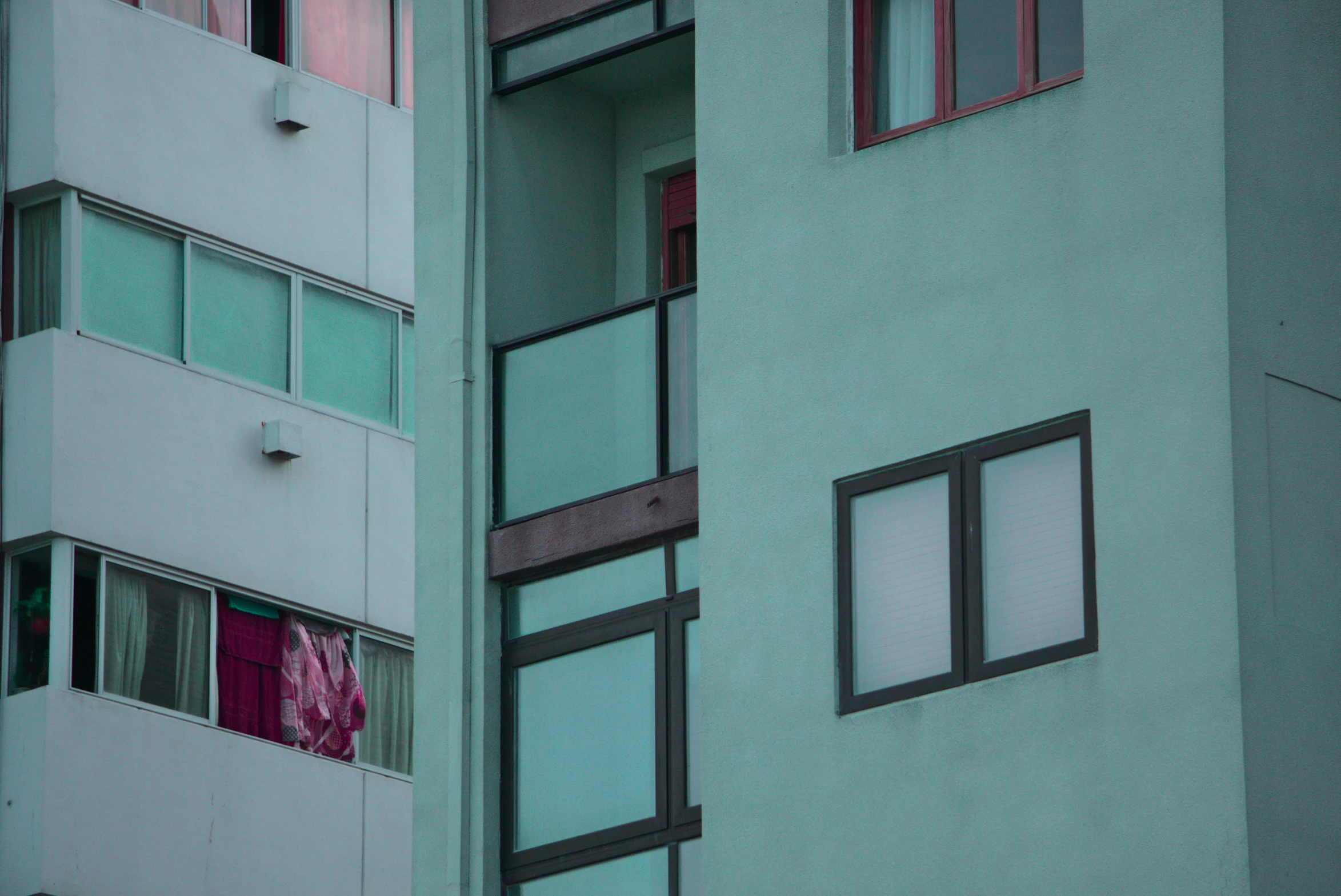 a green building with red and white blinds