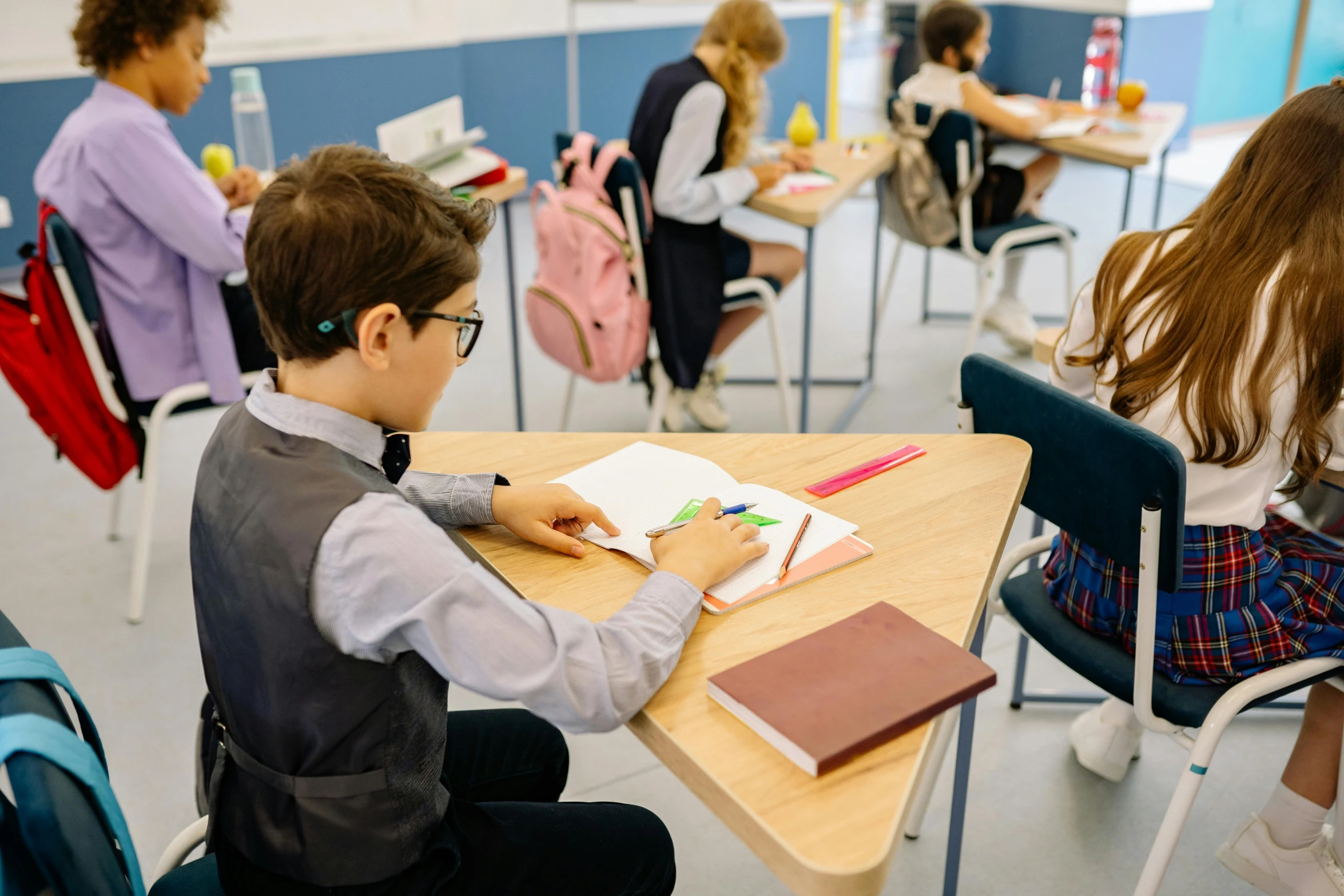 the students are working on crafts while sitting in their desks