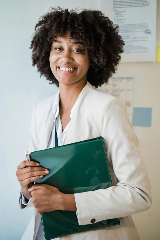 an african american woman holding a folder on her right arm