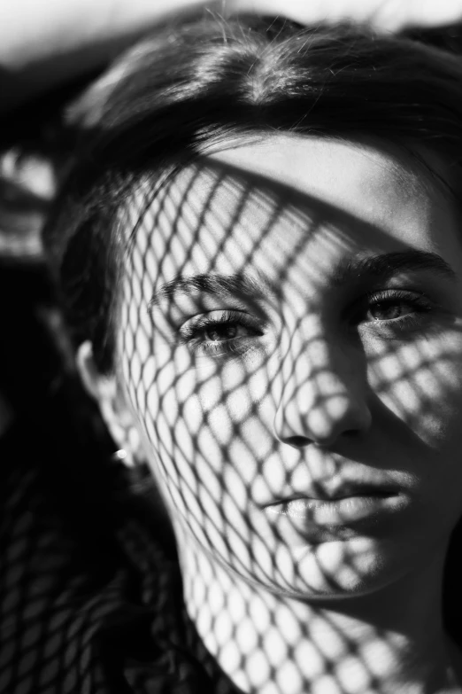 a young woman in a black dress, with a net covering her face