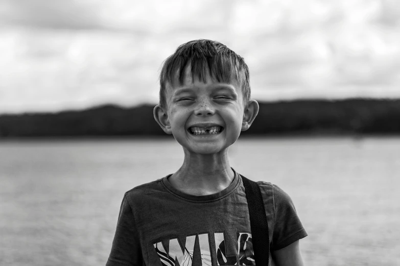 a smiling boy in a black and white image