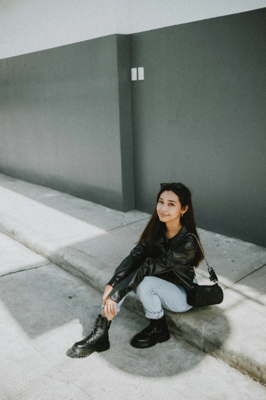 a woman sitting on some steps in front of an empty wall