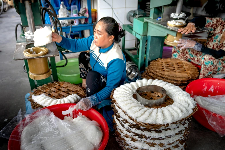 a woman is washing dishes at a food market