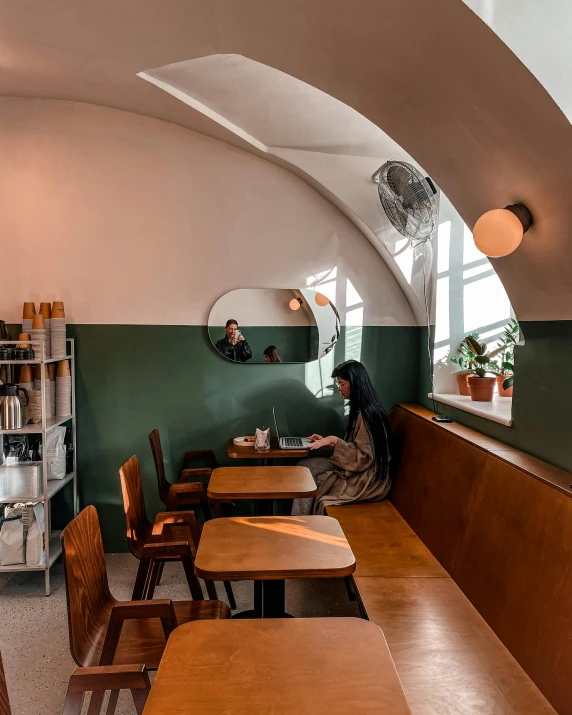 a person sitting at a table in a room with green walls