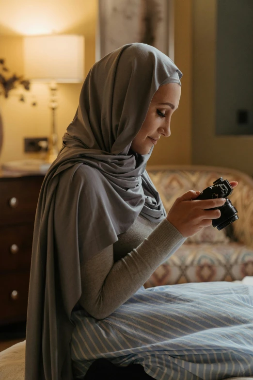 the woman is sitting on her bed looking at the camera