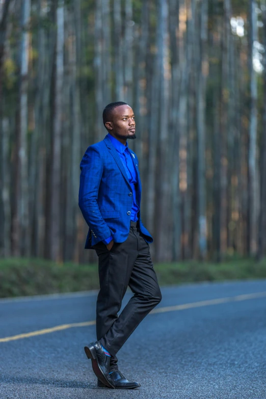 man with blue jacket and black shoes posing for the camera