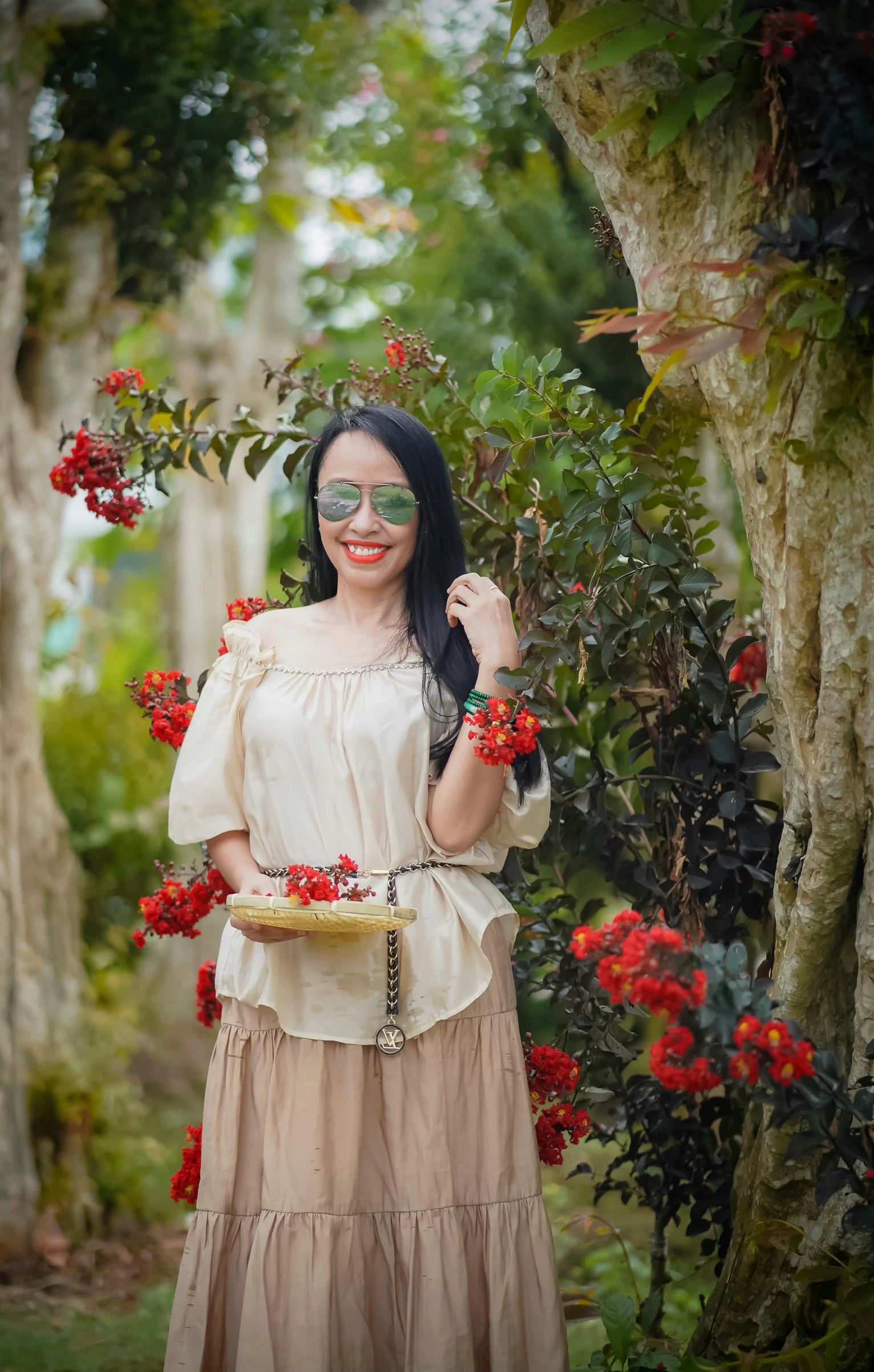 woman in dress and eye glasses standing with tray of flowers