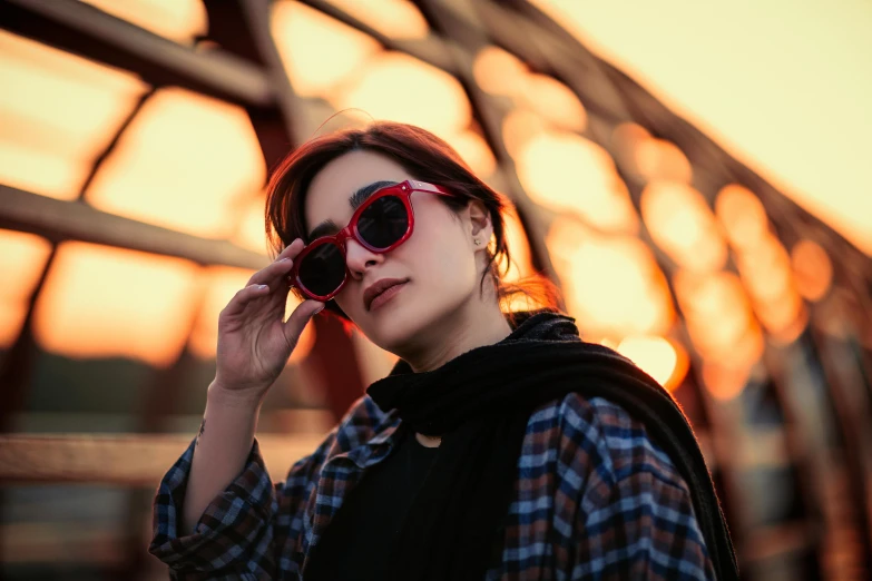 woman wearing red shades and black vest with large sunglasses