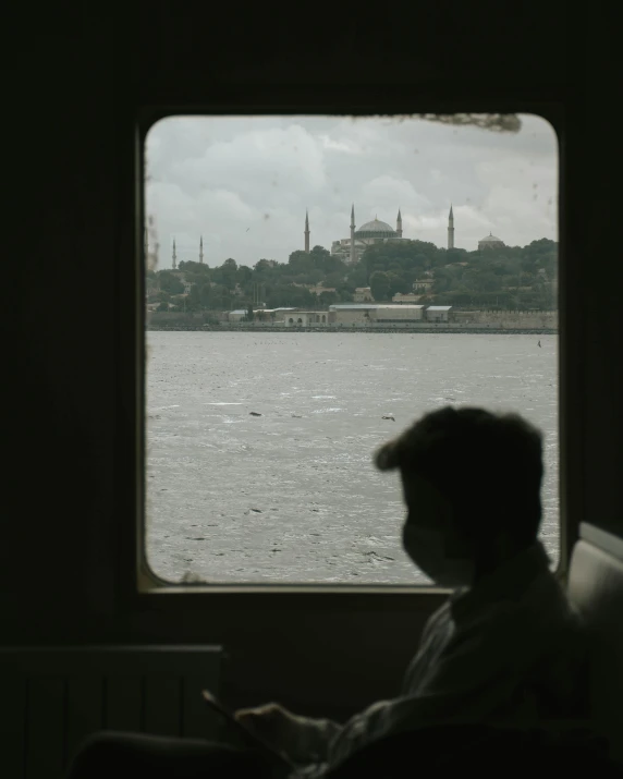 a person sitting in front of a window on a boat