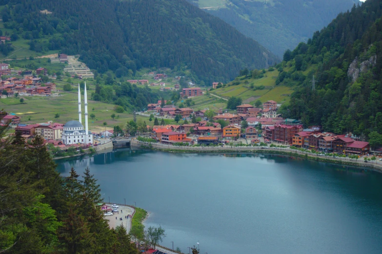 a village sits in the mountains near a lake