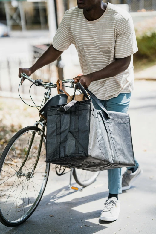 there is a male holding a bicycle and a bag