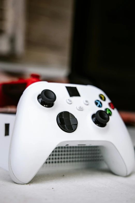 a wii controller sits on a table, next to a red mouse