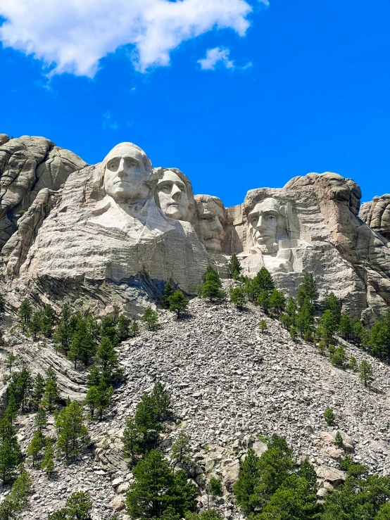 a mountain has mountains carved into it with trees in front