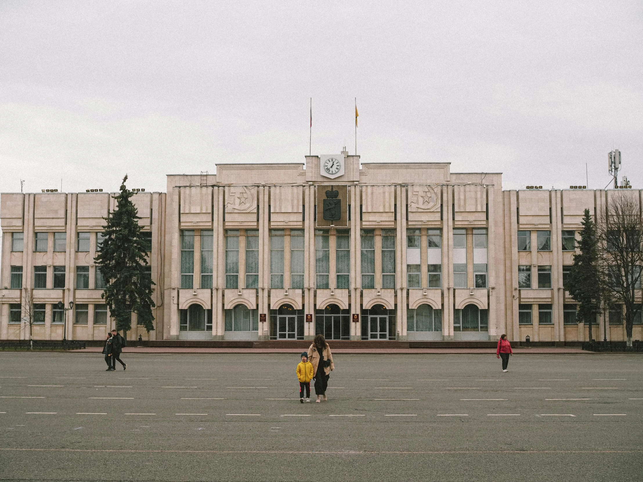 people outside of building with four boys playing soccer in a plaza