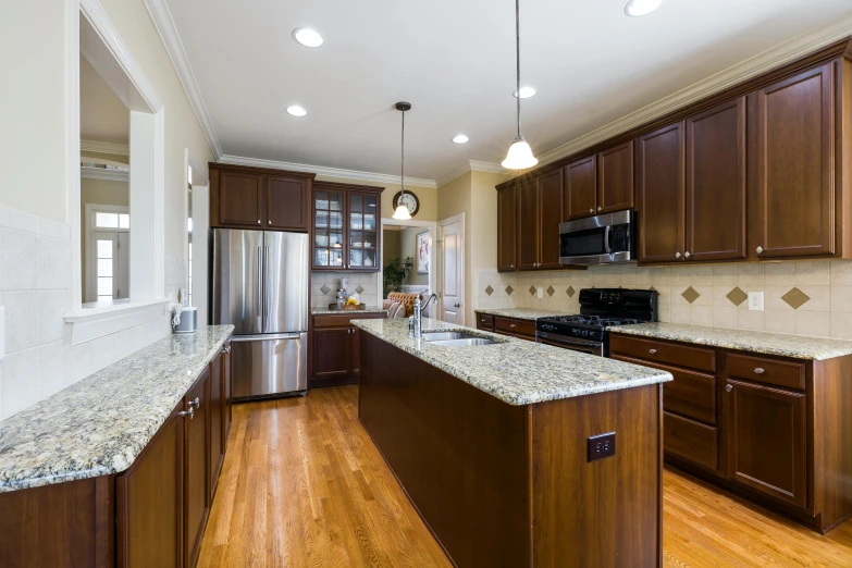 the kitchen has an island, refrigerator and sink