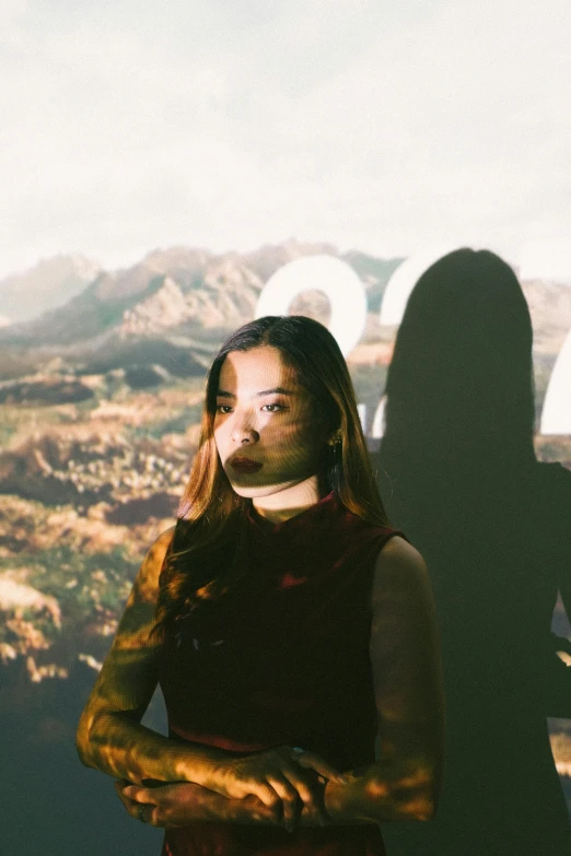 an attractive young woman in front of the hollywood sign