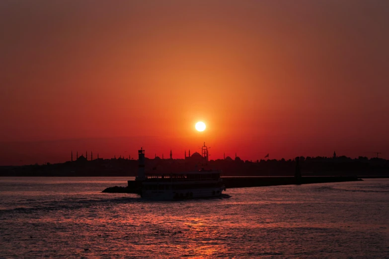 there is a ferry going across the water at sunset