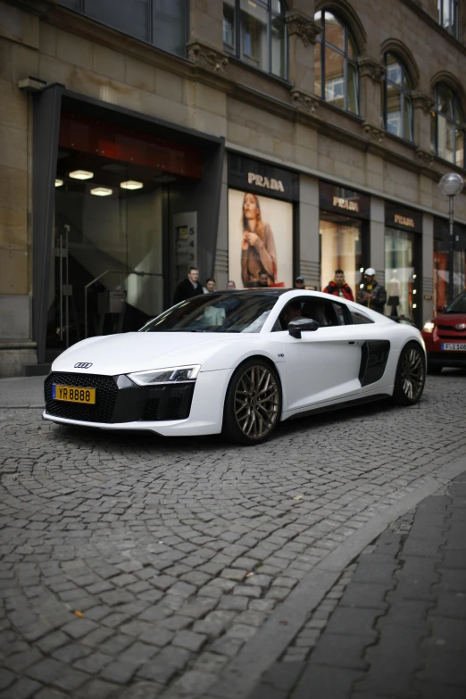 a white audi coupe parked on the side of the street