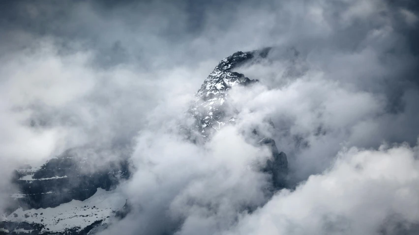 a very tall mountain surrounded by clouds