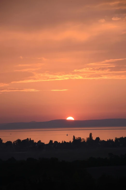 sunset from a hill overlooking a body of water