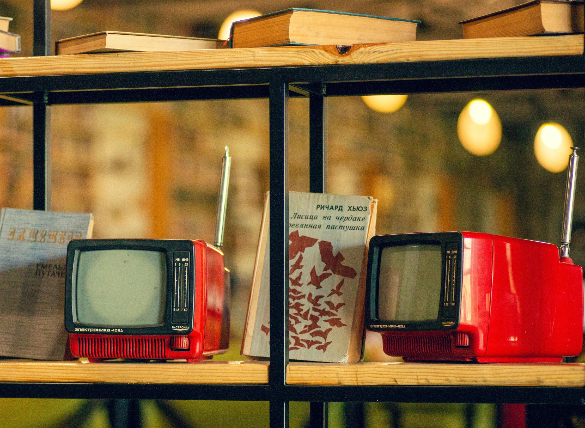 a row of old televisions sit on display in a glass case