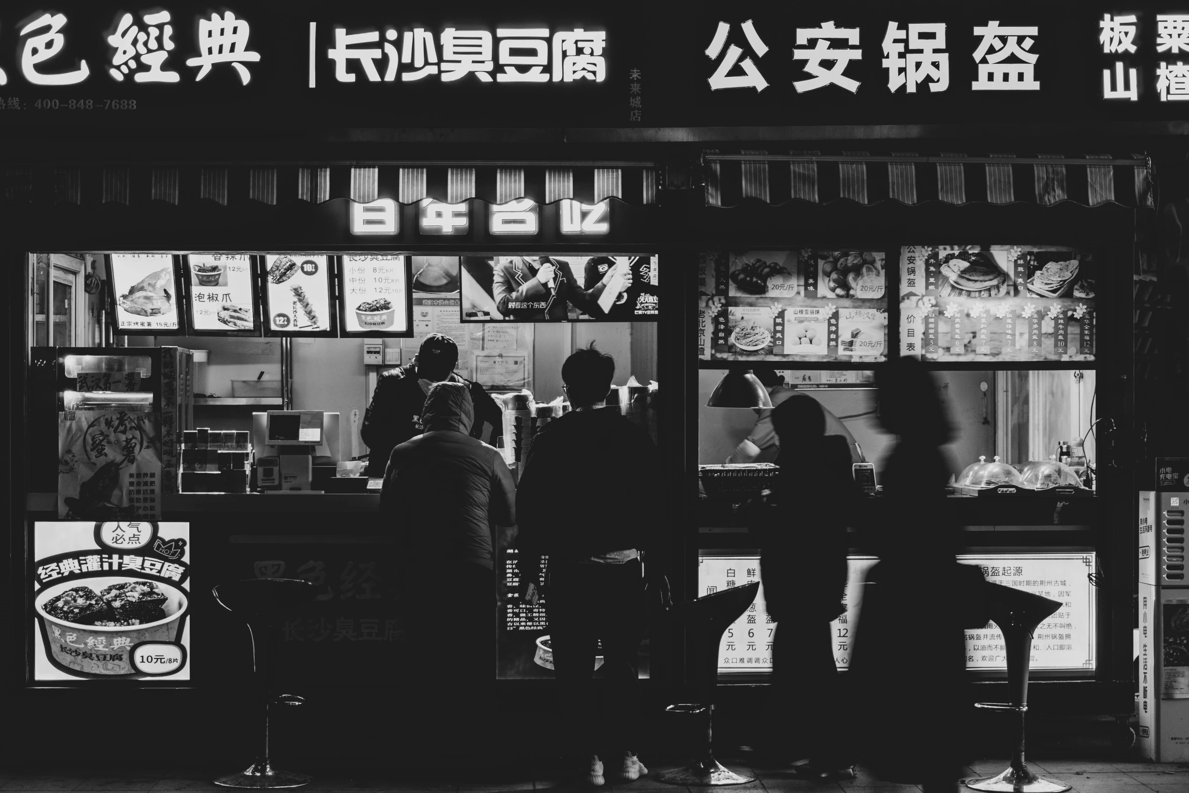 several people standing outside of a fast food restaurant