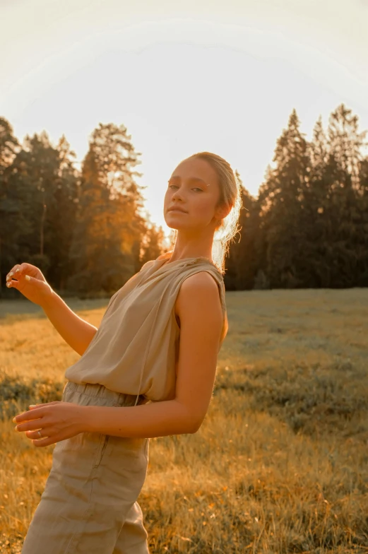 a woman standing in the grass with her arms out