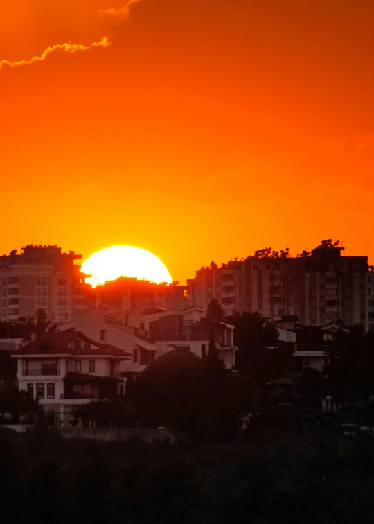 a sunset in front of some buildings in the city