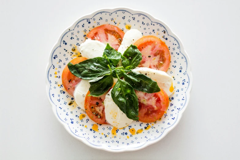 the tomato and mozzarella are garnished with cheese and basil