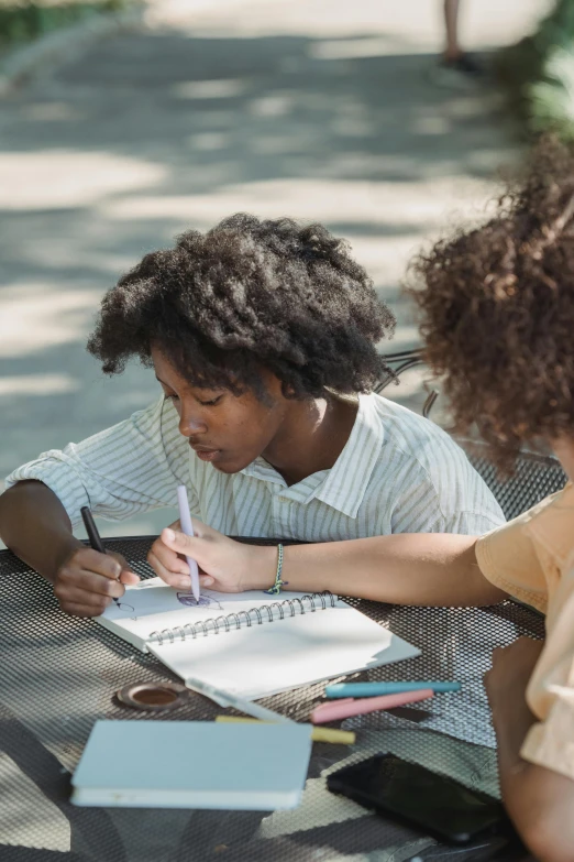 two women sitting at a table studying together