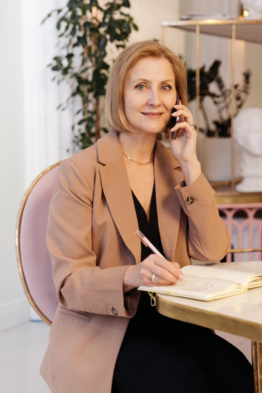 a woman sits at a table talking on a phone