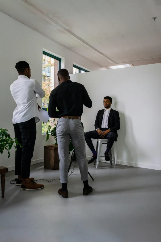 three people standing in a white room