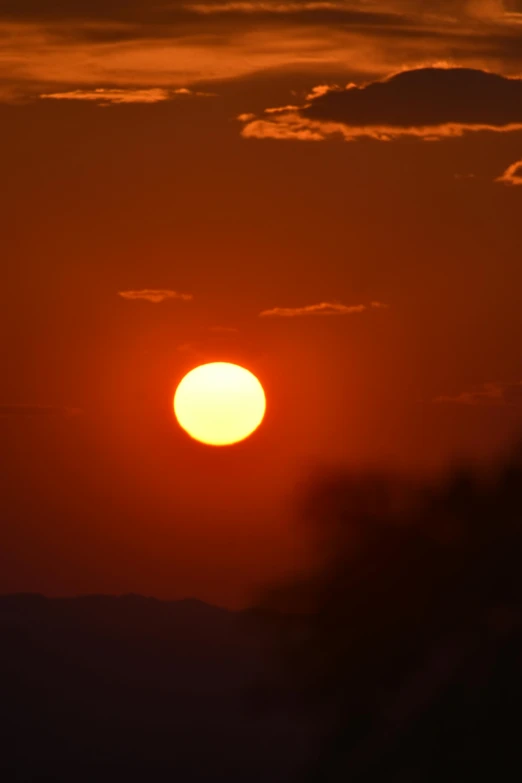 an airplane is flying in the dark and orange sky