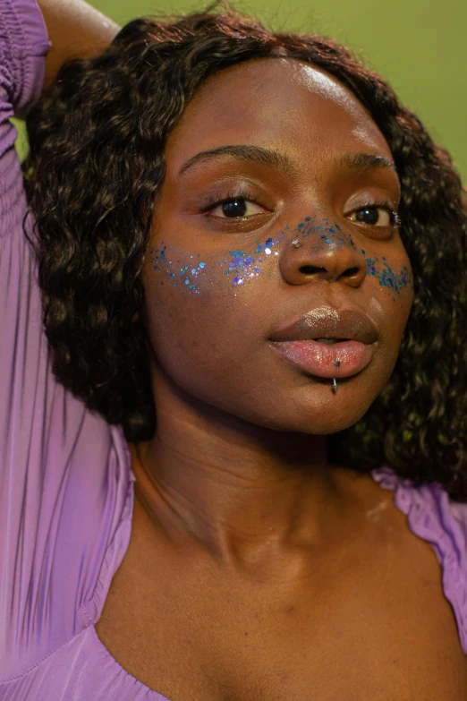 woman with blue and silver body art, half on face