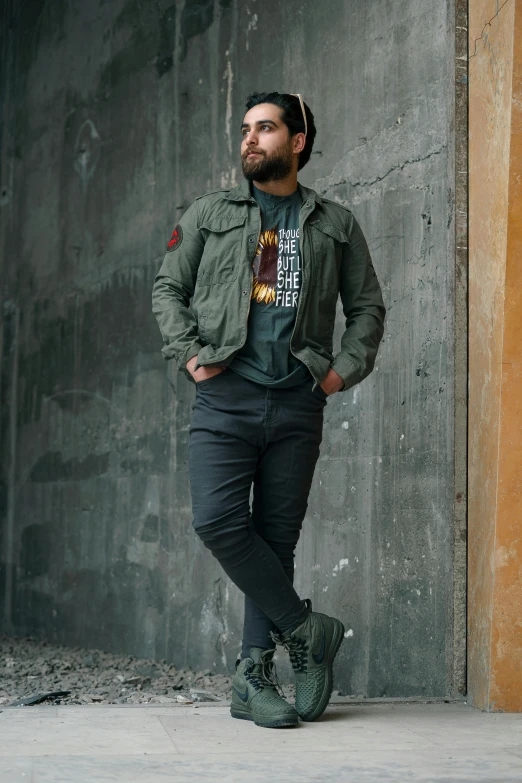 man with beard standing and wearing green jacket