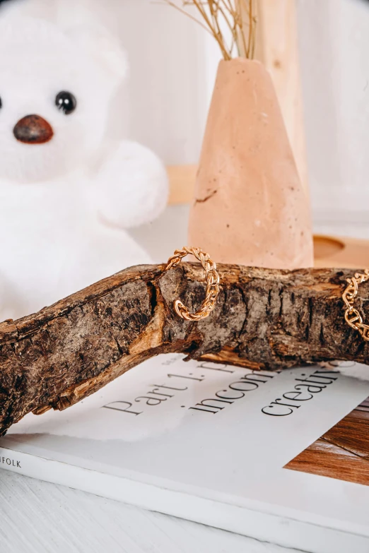 a white teddy bear sitting next to an old log and other decorations