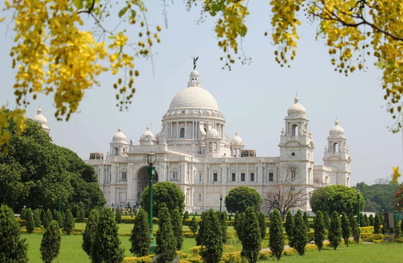 a large white building sitting in the middle of a park