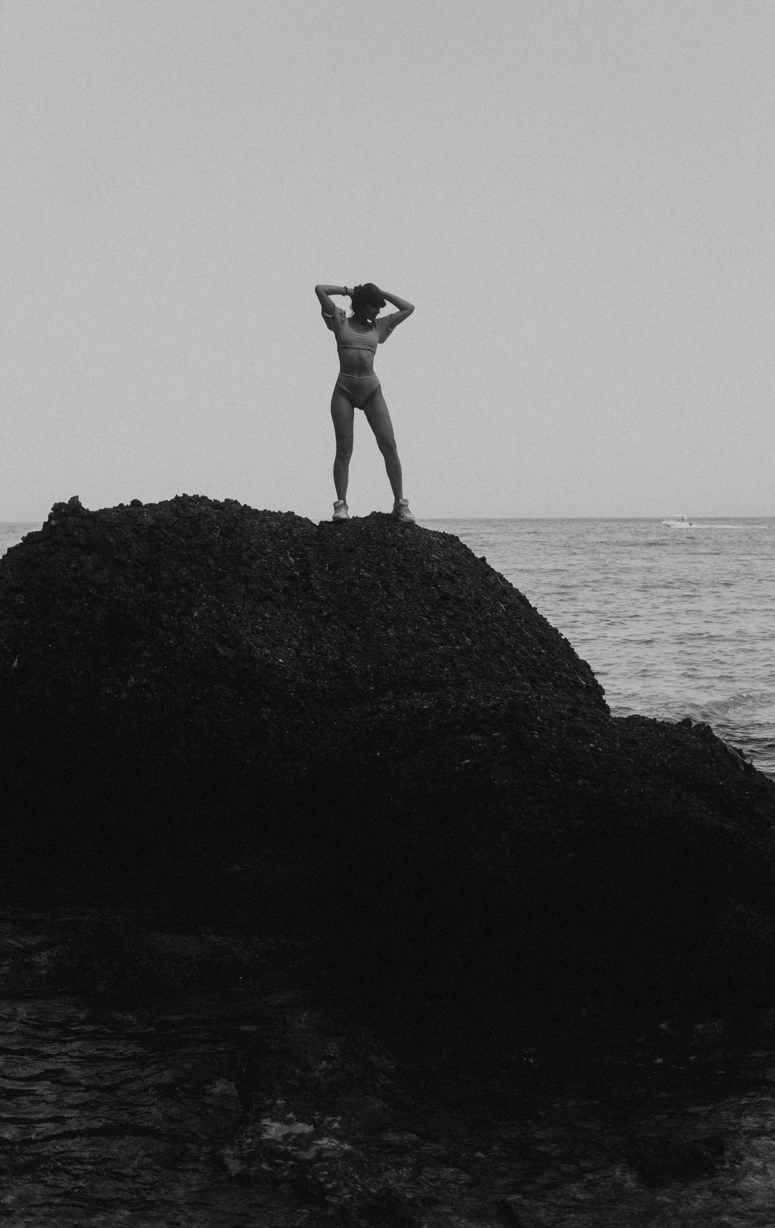 a woman that is standing on some rocks