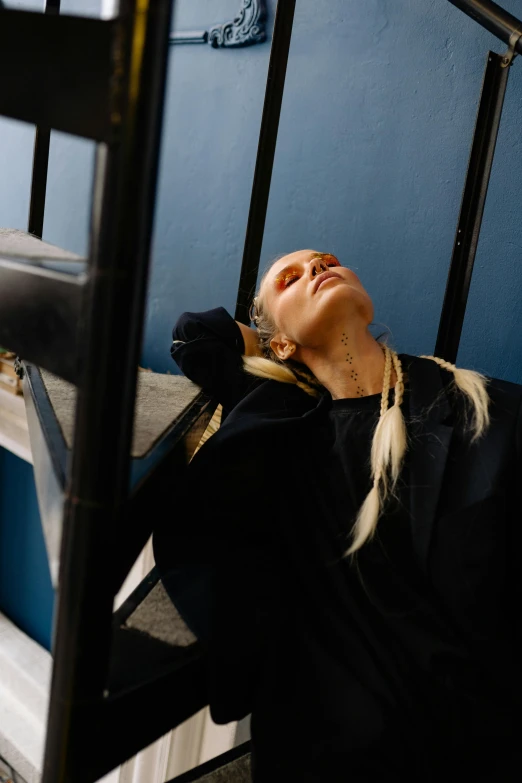 a woman leaning against a railing as she looks out of the window