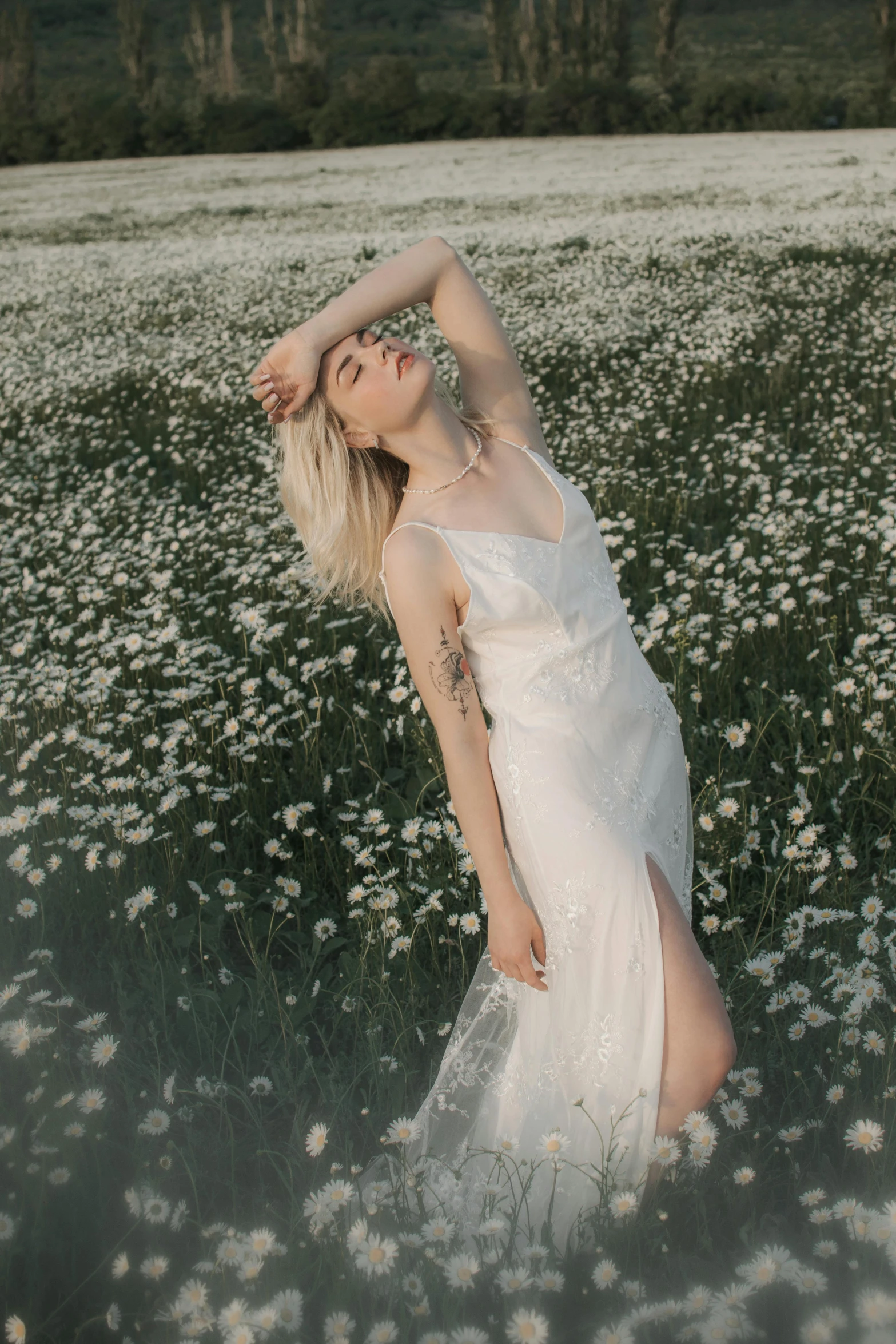 a woman in white is standing in a field