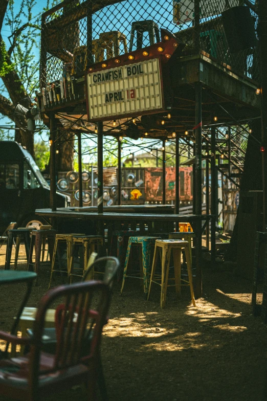 a metal structure with tables, chairs and a sign