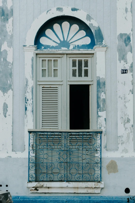 an open window that has shutters in front of a building