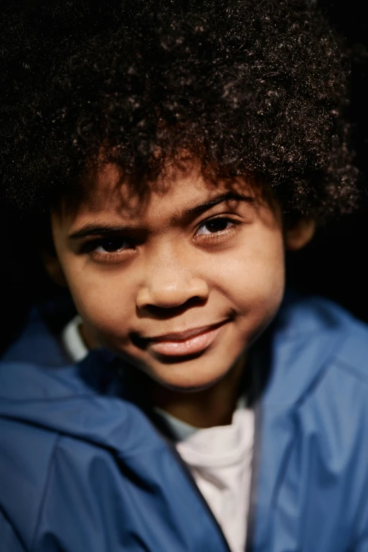 a child is smiling for the camera with hair in the wind