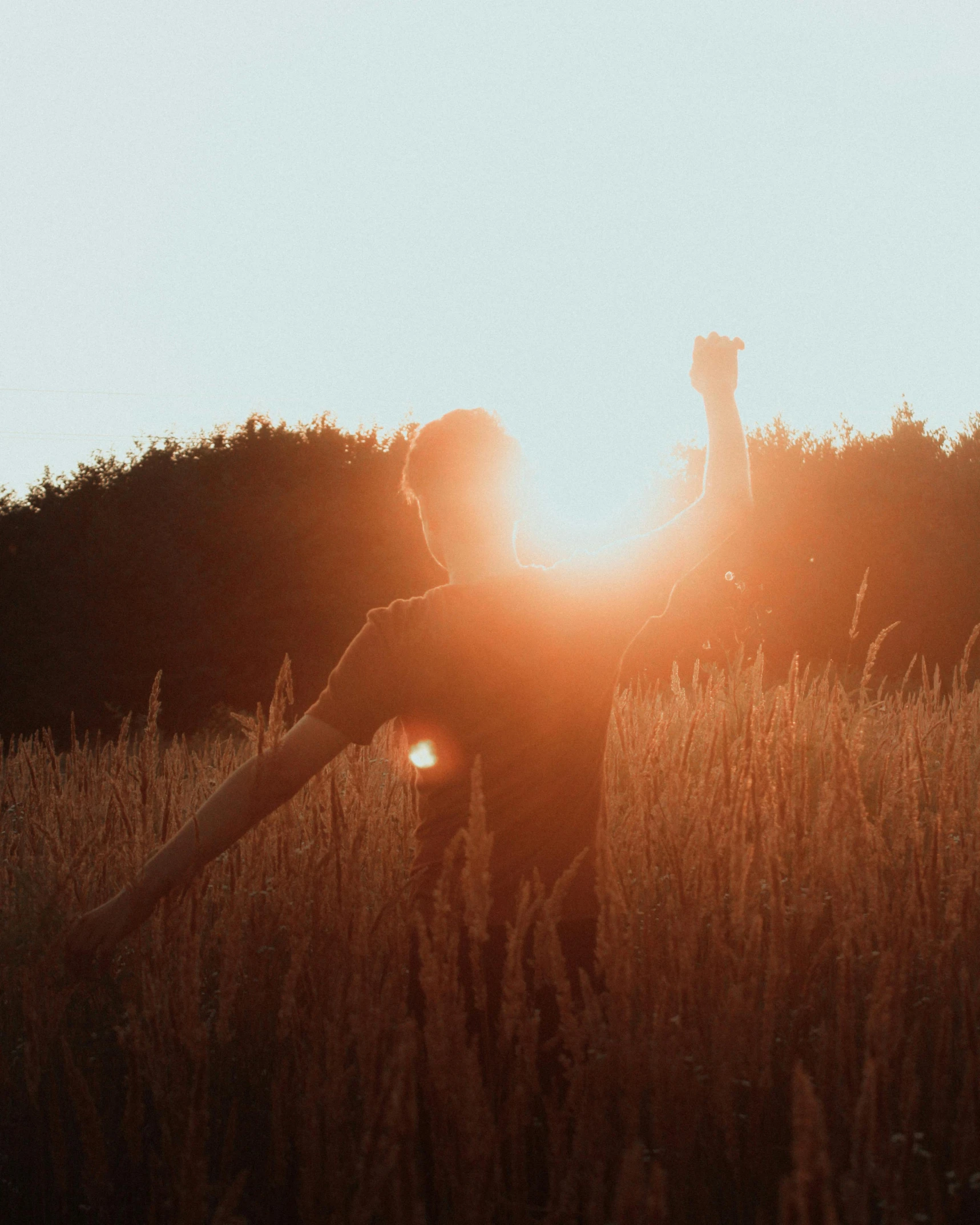 a person holding his hands up in the sun