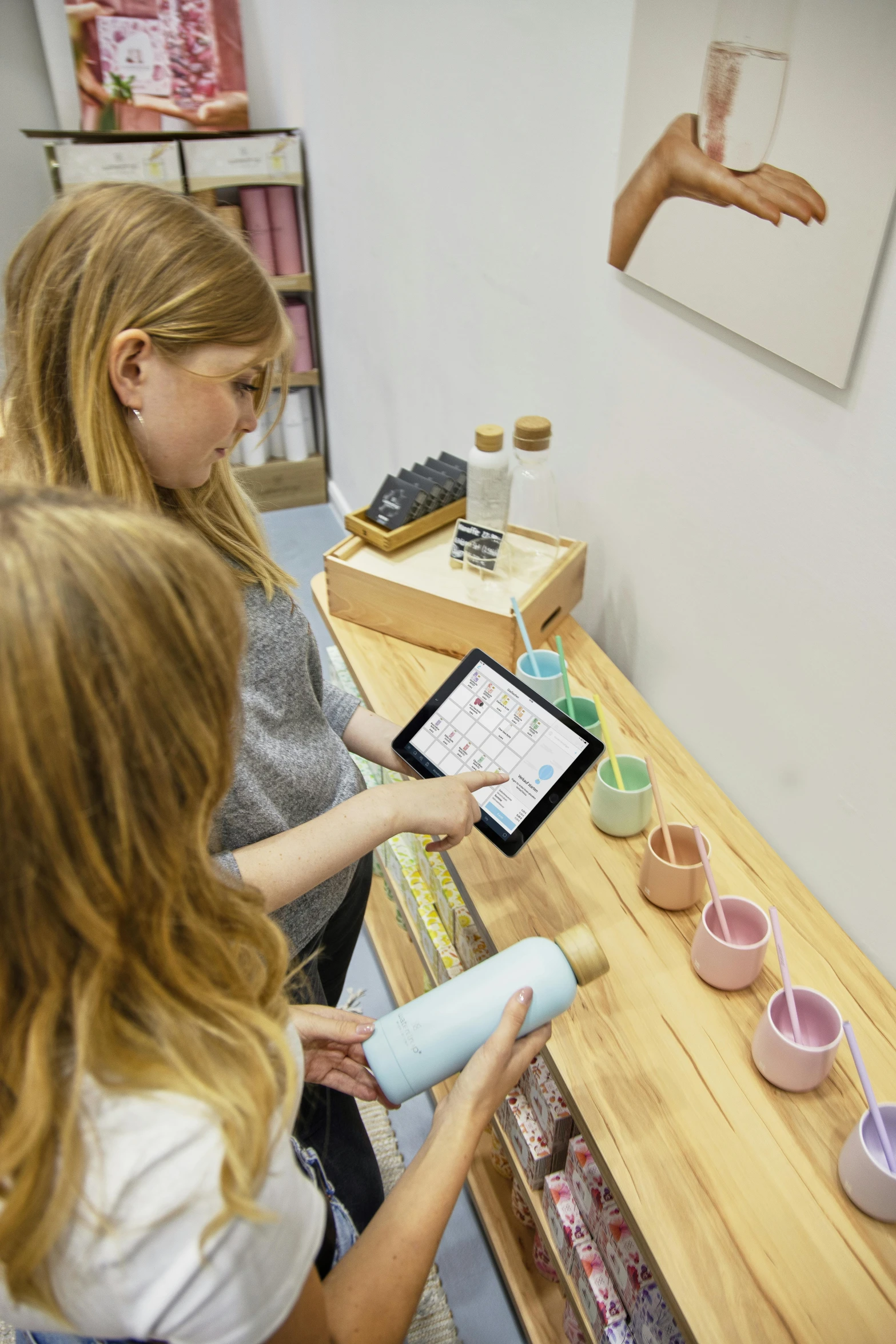 two woman are shown working on a tablet