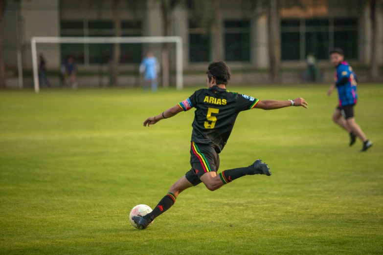 young man kicks a soccer ball around in a field