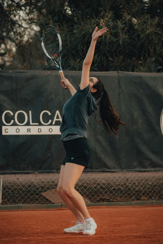 a woman holding a tennis racquet on top of a court