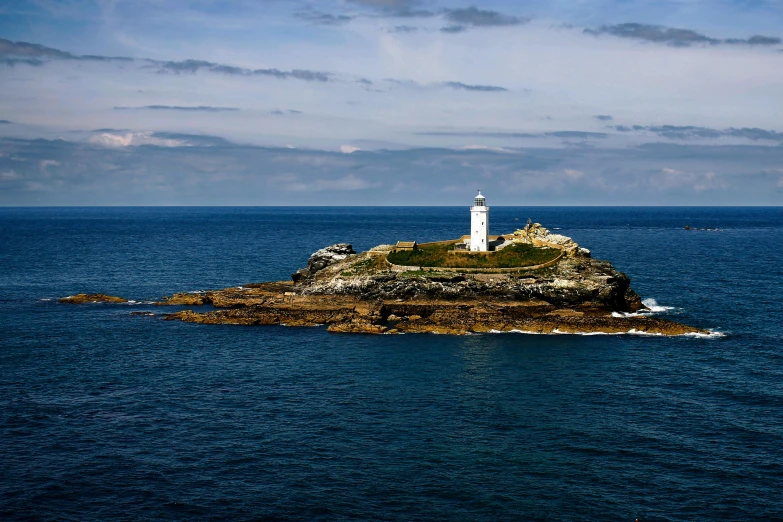 an island with a lighthouse on it floating in the ocean